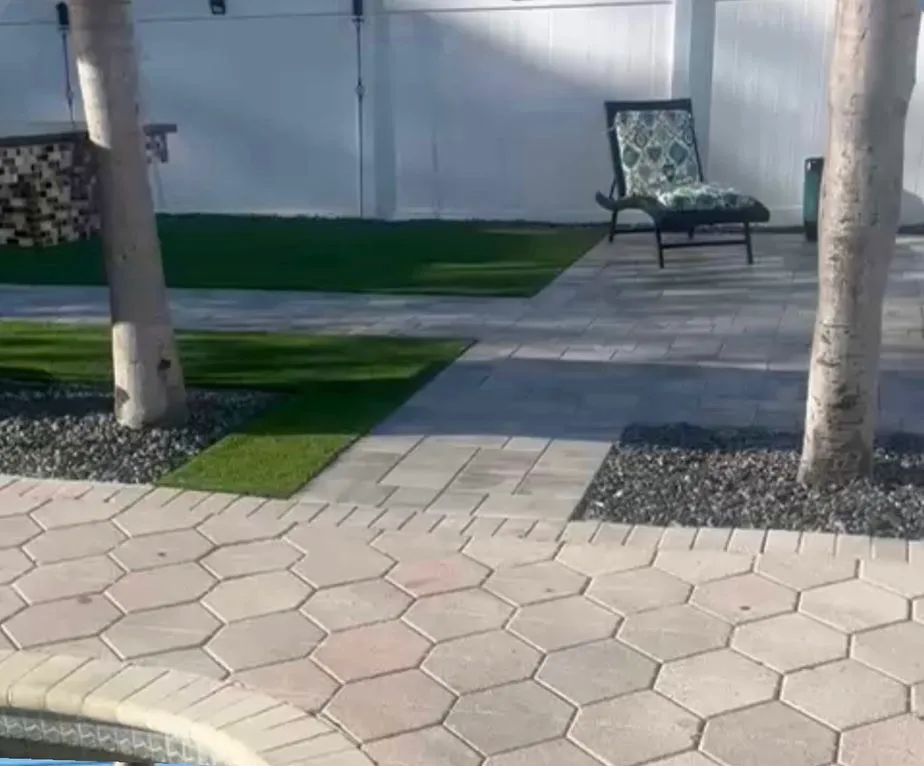 Backyard fire pit with a paver border and Adirondack chairs